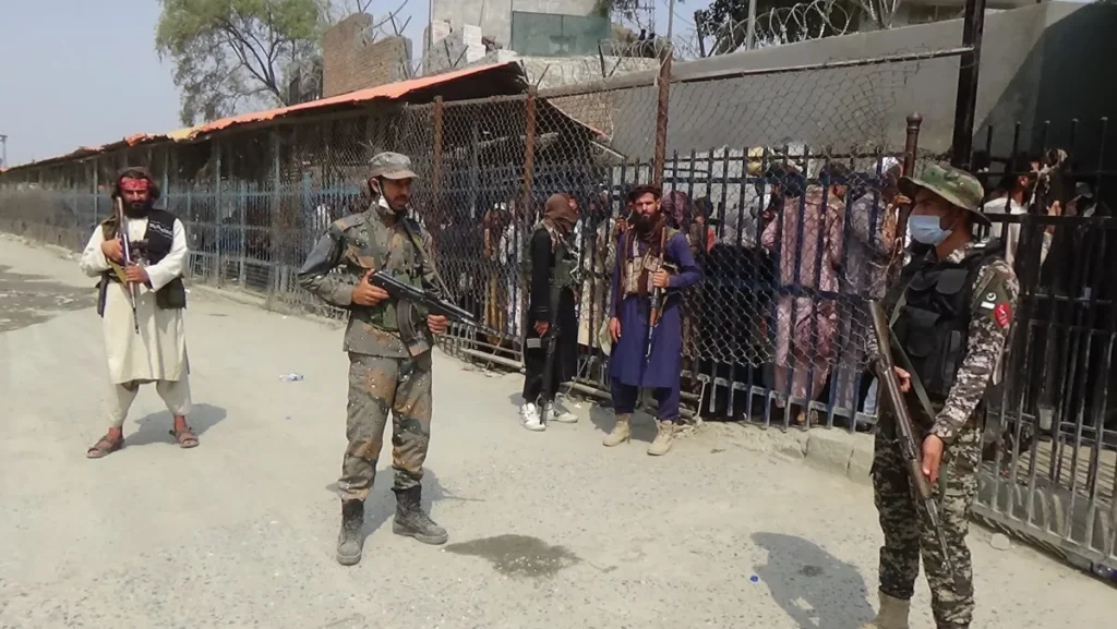 Taliban and Pakistani security keep guard at Torkham border crossing as Afghans wait for the reopening of the border gate to enter Pakistan after Taliban’s takeover on September 19, 2021, in Torkham, Pakistan [Stringer/Anadolu Agency]

